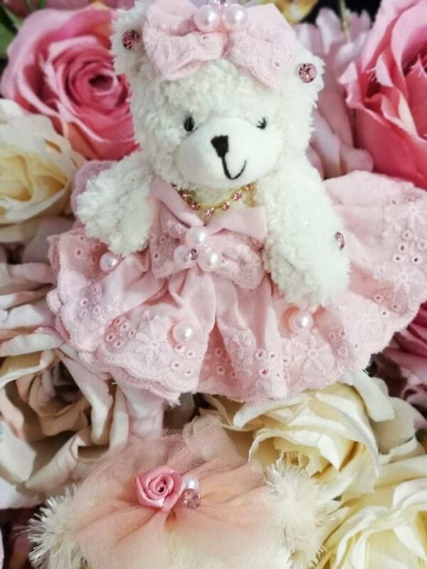 малка плюшена мечка с розова рокля, сладко и пухкаво, подходяща за детски рождени дни и подаръци за деца.