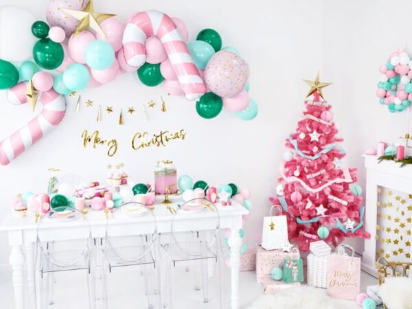Pink Christmas decorations, pastel balloons, party table setup, Christmas tree, birthday celebration, balloon garland, holiday event decor, Party Deluxe Bulgaria, festive indoor party scene, Christmas and birthday party decorations, тематична украса за Коледа и рожден ден.