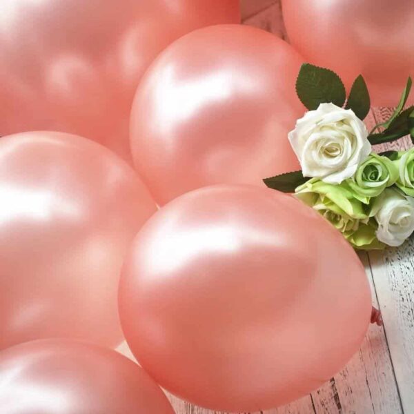 Различни розови балони и бели рози за празнична атмосфера.