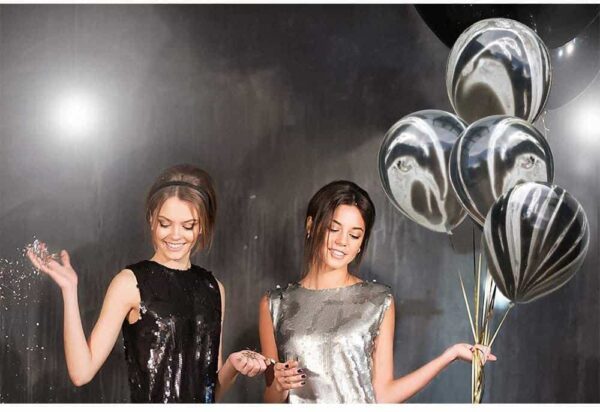 Блестящи балони и забавна празнична атмосфера с млади жени на парти събитие, подходящо за организиране и декорация от Party Deluxe.