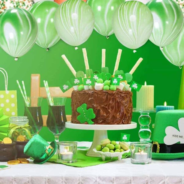 Празнична украса за Ден на Свети Патрик, тлъста шоколадова торта с лепенки и украси с трилистник, зеле, зелен балон и тематични декорации, подходящи за празнуване.
