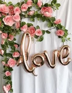 Златисти балони със формата "love" и розови рози, идеални за романтични празници и сватби.