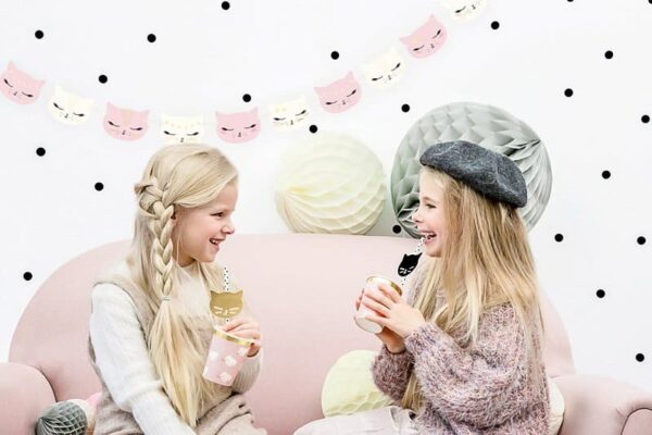 красиво декорирана детска парти стая с котешки фенери и хартиени фенери, боядисани в пастелни тонове, чудесно място за парти с приятели и забавни моменти като децата с чаши за напитки.