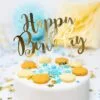 Хубав торт за рожден ден с "Happy Birthday" украсител и макарони, празнична атмосфера, сладки изкушения и конфети, перфектен за парти и специален повод.