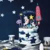 Звезди, космически ракетки и астронавти на торта с тема космическо приключение за детско парти. Перфектно за космическа-themed празнична обстановка.