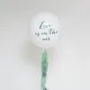 Балон с надпис "Love is in the air" със зелени декоративни листа за романтични събития и тържества.