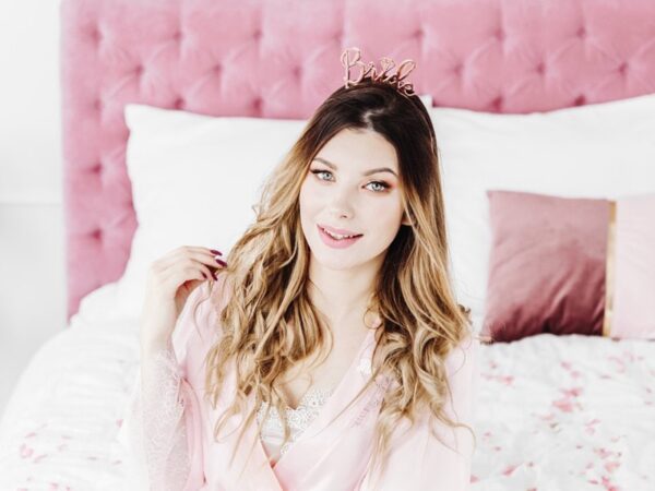 богата рожденничка с розова корона и розово сако, женска, уютна спалня, празничен тост, бляскава подготовка за парти, момиче с усмивка, специален ден, Party Deluxe.
