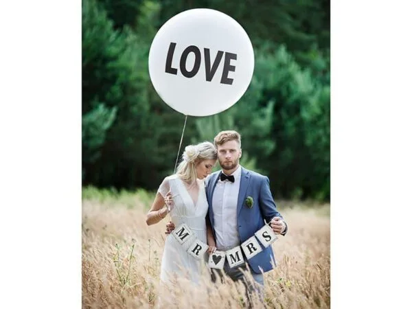 LOVE балон с надпис, сватбена фотосесия на открито, щастливи младоженци, свадбено парти в природна обстановка, празнични украси за сватба, тематична фотосесия, романтично настроение, декорации за събития, сватбени елементи, Party Deluxe, събиране на приятели и семейство, елегантни сватбени аксесоари, персонализирани празнични украси.