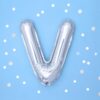 Метален балон във форма на V на син фон с бели и сребърни конфети, подходящ за празненства и събития.