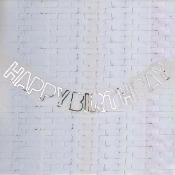 Картинка със сребърна гирлянда с надпис "HAPPY BIRTHDAY" на бял тухлен фон за празненство.