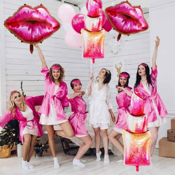 Pink balloons with lips and cake-shaped decorations for a bachelorette party.
