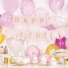 Рожденденска украса с балони и торта, празнична обстановка за парти от Party Deluxe, подходяща за рожден ден с розови, златисти и бели елементи.