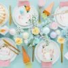 Pink Easter table setting with bunny-themed plates, colorful eggs, and spring flowers for festive celebrations.