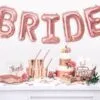 розови балони с надпис "BRIDE" за сватбени тържества, сватбени декорации, торта и чаши с розови акценти, идеи за булчински партита, празнична атмосфера, украса за сватбена вечер, Party Deluxe бранд.