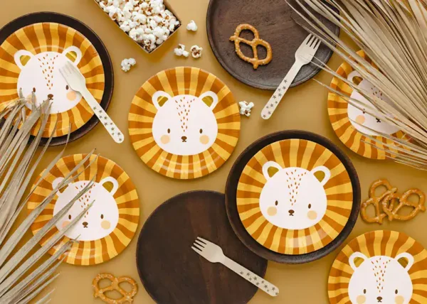 заглавна снимка на рожденденска маса с хартиени чинии, чаши и салфетки с мече, подходяща за детска партито, с декорации и сладки изкушения.