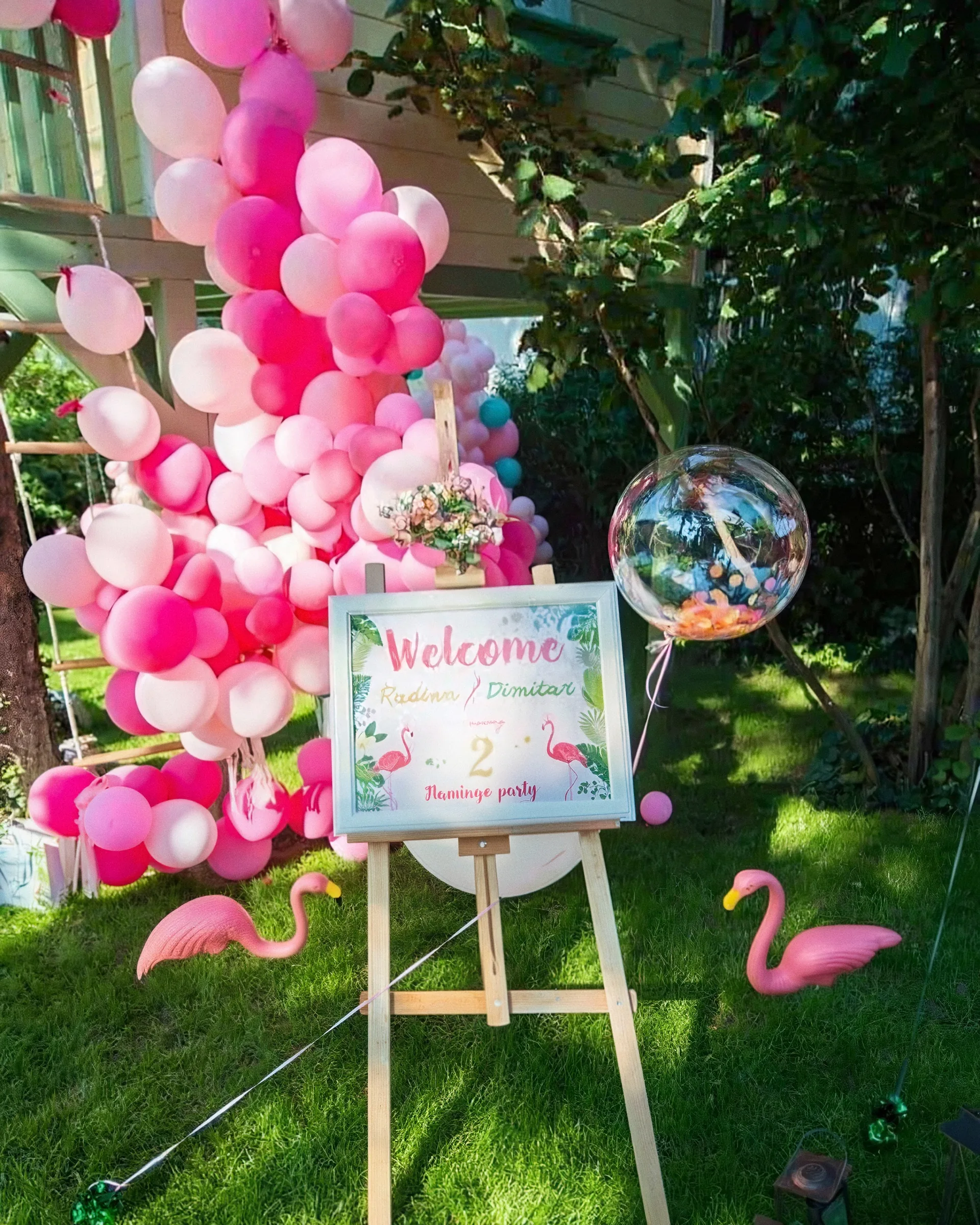 Фламинго парти на трева с розови балони и табела Welcome на статив